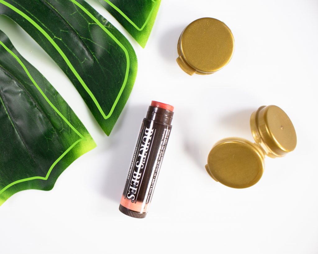 Tinted lip Balm with gold metallic plastic sampling container from Laconsbeauty with palm leaves